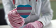 © Nadzeya - Healthcare professional holding a heart-shaped trans transgender pride symbol while discussing patient