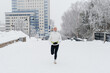 © Anton Pentegov - young caucasian woman running in park in winter, white sports jacket, black trousers and small waist bag on belt, active lifestyle concept, jogging in winter, sports life, copy space
