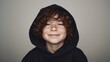 © Oleksandr - A close-up of a young boy with red curly hair, freckles, and a black hooded sweatshirt, smiling. He has a friendly expression, set against a plain background. 174/180