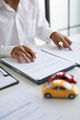 © Supitnan - A man signing a contract for a car loan, lease, vehicle registration or insurance policy. Concept for Sales Contract, Financing Agreement, Insurance Policy, Vehicle Registration.