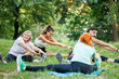 © ivanko80 - Group of people stretching in a park during a fitness class on a sunny day