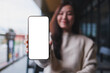 © Farknot Architect - Mockup image of a woman holding and showing at a mobile phone with blank white screen