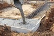 © imageSTOCK - Pouring concrete for foundation at construction site in sunny weather