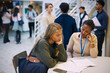 © Maskot - High angle view of teenage high school student examining test results with female professor in lobby