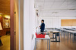© Maskot - Male professor standing near whiteboard in empty classroom at high school