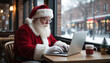 © Юлия Васильева - Santa Claus sitting at a table and working on a laptop in a cafe