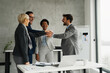 © Novak - A group of colleagues celebrating business achievements in an office setting, sharing smiles and congratulations.