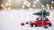 © ON - Studio - Red vintage toy car carrying a Christmas tree on the roof. Winter holiday background with snow and bokeh lights. Xmas delivery concept with copy space