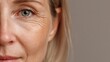 © Babb - A woman gazes softly at the camera revealing her expressive eyes and gentle smile. The warm lighting enhances her natural features and subtle wrinkles celebrating beauty at any age.