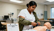 © Anna - Nursing student practicing taking blood pressure on a medical mannequin. Female healthcare professional in training at a clinical skills lab
