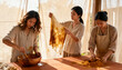 © Anna - Three artisan women working on a natural fabric dyeing project. Making handmade textiles in a sunlit craft workshop. Sustainable and traditional craftsmanship concept