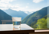 a glass of water on the table with a cool mountain view