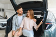 © Serhii - Happy young couple choosing new car at dealership