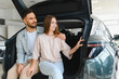© Serhii - Young couple choosing new car at dealership