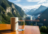 a glass of water on the table with a cool mountain view
