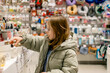 © Yulia - A girl choosing goods in a store, which, judging by the selection, could be a store of various pleasant little things.