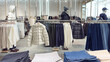 © Evgeniia Primavera - Modern clothing store interior with neatly arranged jackets, sweaters, hoodies denim on racks and shelves. Neutral colors, clean layout mannequins create stylish, organized retail shopping atmosphere