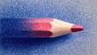 © Formoney - A red colored pencil lies against a textured blue background, highlighting its sharpened tip and vibrant hue. Perfect for art enthusiasts and creative projects.