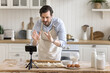 © fizkes - Confident man chef shooting culinary vlog in kitchen using phone