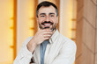 © Maria Vitkovska - Portrait of happy smiling man thinking with beard and hand on chin
