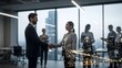 © TANZIM22 - Business professionals shaking hands in a modern office with city lights reflecting on the glass