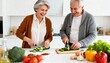 © MI Sumon - Happy senior couple laughing and smiling while preparing a healthy meal together, chopping fresh green zucchini on cutting boards in a bright modern white kitchen, enjoying active retirement lifestyle
