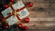 © FERRY - Christmas gift box with red ribbon and ornaments on wooden surface.