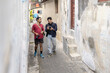 © Ibenk.88 - Two photographers walking and reviewing shots in a narrow alley