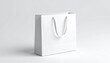 © deni - Blank white paper bag mockup with thin silk handle open, isolated, 3D rendering