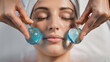 © olgakris - Relaxing facial massage with blue ice globes used in a cooling skincare therapy routine for de-puffing, soothing the skin, and enhancing circulation in a spa or at-home self-care beauty ritual