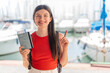 © luismolinero - Young pretty Ukrainian woman holding a passport at outdoors pointing up a great idea