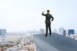 © Who is Danny - Businessman looking into the distance from rooftop edge over modern city background, symbolizing vision, future planning, and ambition.