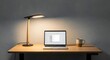 © MDRAMZAN - Modern workspace showcasing a sleek laptop, stylish lamp, and inviting coffee mug for productive work or cozy online browsing in a minimalist setting