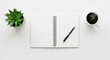 © Kolepfg - Blank notebook, pen, coffee, and plant on a white desk - workspace flat lay, top view, minimal
