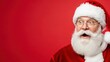 © Tatiana - Man dressed as Santa Claus with a surprised and excited expression on a red background with copy space. Christmas holiday mood.