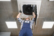 © Serhii - Hvac technician repairing air conditioning system on ceiling