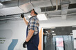 © Serhii - Hvac technician installing ventilation system in modern office building