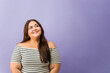 © AntonioDiaz - Plus size woman smiling looking up daydreaming