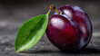 © Sabana - Close up of a plum with a green leaf and water droplets on a dark background
