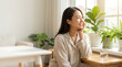 © moshi-moshi - 部屋着姿でリラックスし、頬に手を添える若い日本人女性