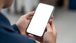 © sagara - Close-up of a person holding a modern smartphone with a blank white screen