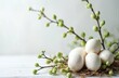 © Viktor - White speckled Easter eggs lie in nest with green budding branches. Spring holiday composition still life on light wooden background. Minimalist festive decoration for seasonal celebration, greeting