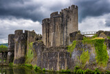 Medieval stone ruins and towers of Caerphilly Castle surrounded by its water moat