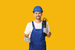 © Pixel-Shot - Portrait of male electrician with crimper and wires on yellow background