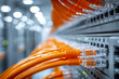 © Mikhail Vorobev - Network cables connected to a modern server rack inside a data center with focus on several orange cables plugged into the hardware ports