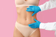 © Pixel-Shot - Young woman with flat belly and plastic surgeon on pink background, closeup