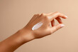 © Vitalii - Woman's hand with a stroke of white moisturizing cream applied for skincare demonstration
