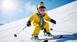 © Milan - Happy little boy skiing downhill on a snowy mountain slope. Child in yellow winter clothes enjoying winter sports. Sunny day with blue sky