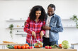 © sofiko14 - An African-American couple prepares a healthy salad together in a bright, modern kitchen, embracing a lifestyle of wellness and togetherness.