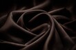 © Julia - Warm light shines down on brown satin fabric, which elegantly drapes in soft, flowing waves and folds